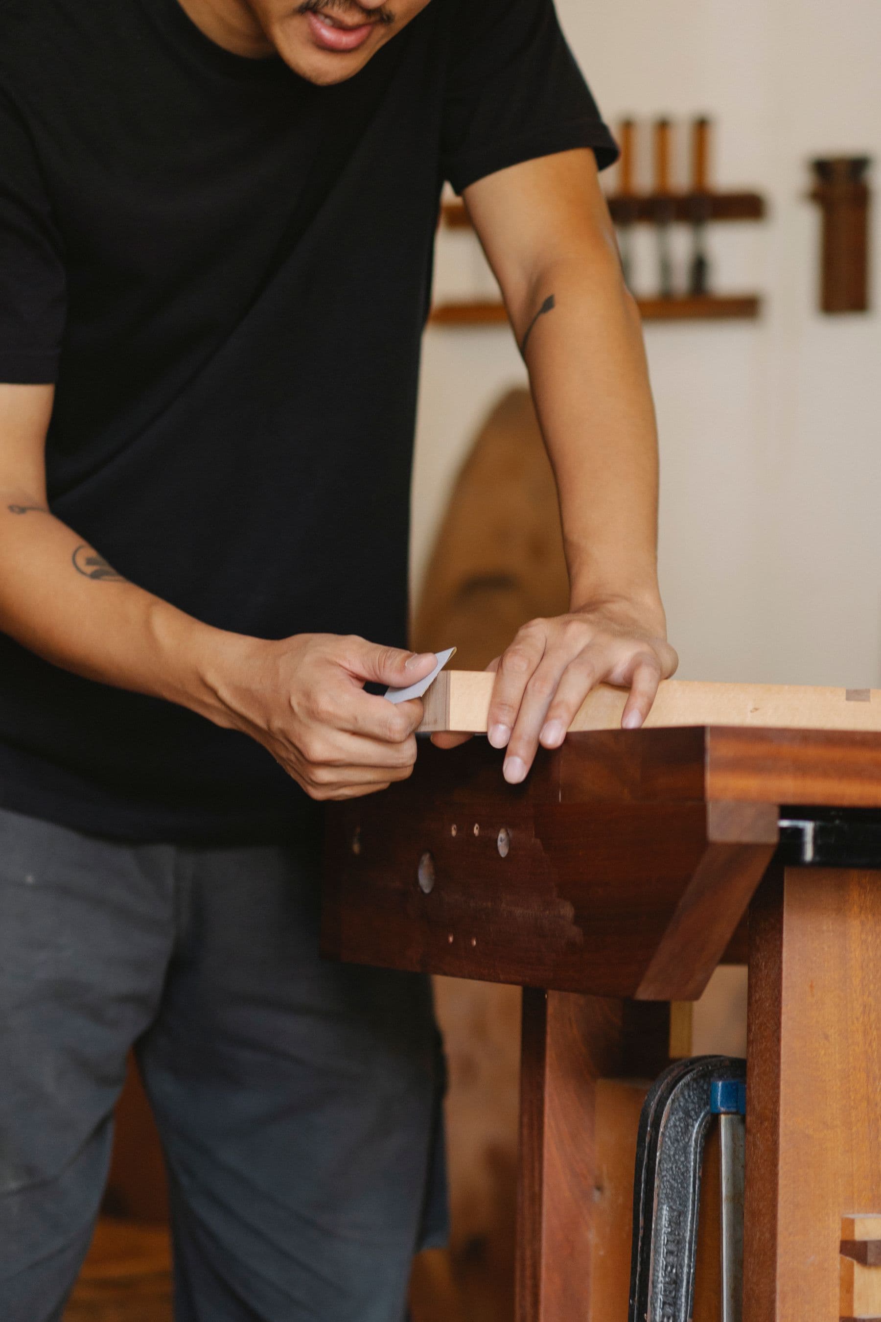 Craftsperson shaping a hardwood furniture frame by hand